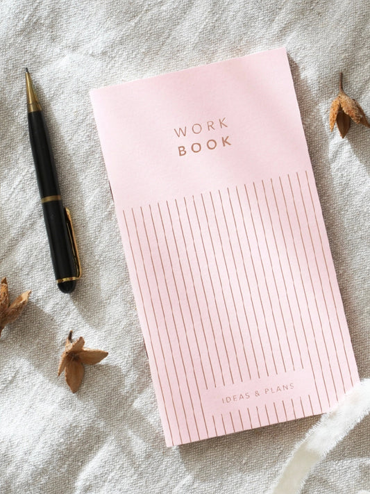 Rosa arbetsbok med penna