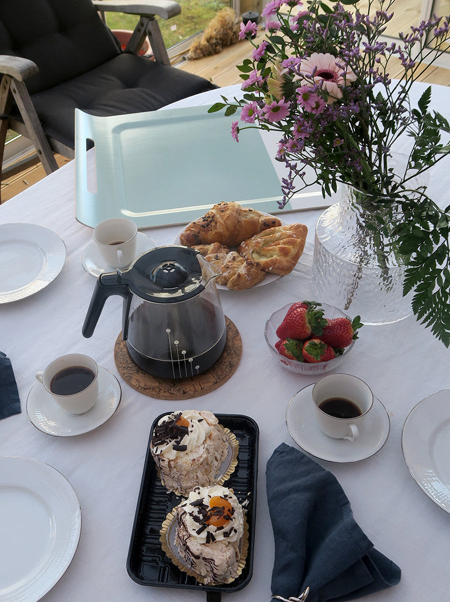 Fikabild där bricka med handtag finns i bakgrund